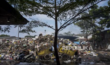 Pengendara melintas di depan Tempat Pembuangan Sampah Sementara (TPS) -- ilustrasi