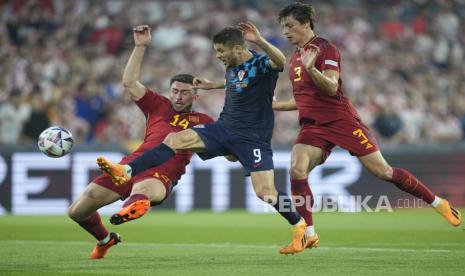 Pemain Kroasia Andrej Kramaric (tengah), Aymeric Laporte dari Spanyol (kiri) berebut bola saat pertandingan sepak bola final Nations League antara Kroasia dan Spanyol di stadion De Kuip di Rotterdam, Belanda, Senin, (19/6/ 2023).