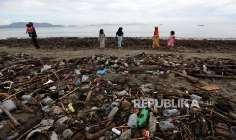 Anak-anak berjalan di antara sampah yang terdampar di pantai Kampung Jawa di Banda Aceh. Ton sampah plastik, sebagian besar botol air dan kemasan makanan yang berasal dari sungai perkotaan, terdampar setelah mencapai laut lepas.