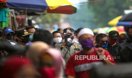 Wali Kota Bogor Bima Arya (tengah) menyampaikan imbauan kepada warga yang berkerumun saat sidak di kawasan Pasar Anyar, Kota Bogor, Jawa Barat, Ahad (17/5/2020). Meskipun Kota Bogor sedang menerapkan Pembatasan Sosial Berskala Besar (PSBB) jilid ke-3 hingga tanggal 28 Mei mendatang tapi masih banyak warga yang melanggar aturan tersebut dengan berkerumun, tidak memakai masker dan tidak menjaga jarak fisik (physical distancing) di pasar tersebut saat pandemi COVID-19