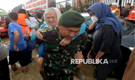 Personel TNI menggendong lansia korban banjir di Pondok Gede Permai, Bekasi, Jawa Barat, Selasa (4/3/2025). Sebanyak 7 kecamatan di Kota Bekasi terdampak banjir akibat meluapnya Kali Bekasi. Kecamatannya meliputi Jatiasih, Bekasi Selatan, Bekasi Timur, Bekasi Utara, Bantargebang, Medan Satria, dan Pondok Gede. Terdapat sekitar 20 lokasi posko pengungsian yang disiapkan. Posko-posko ini tersebar di kawasan Perum Pondok Gede Permai dan wilayah terdampak lainnya. Pemerintah Kota Bekasi telah menetapkan status tanggap darurat bencana banjir. Total pengungsi akibat banjir bekasi mencapai 5.000 KK, dengan jumlah jiwa yang terdampak 16 ribu jiwa secara keseluruhan.