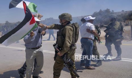 Pasukan tentara Israel bentrok dengan pengunjuk rasa Palestina yang membakar ban dan memblokir jalan yang melewati desa Mughayer, Tepi Barat, utara Ramallah, Jumat, 29 Juli 2022. Warga Palestina yang memprotes aktivitas permukiman Israel menutup jalan utama dan bentrok dengan pemukim Israel dan tentara yang menggunakan gas air mata untuk membubarkan mereka. Organisasi Islam Internasional Kecam Pembakaran Alquran oleh Pemukim Israel