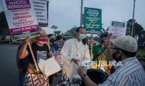 Relawan Pemuda Lintas Agama membagikan takjil dengan membawa poster ucapan selamat Ramadhan dan Lebaran kepada umat Muslim di Solo Baru, Grogol, Sukoharjo, Jawa Tengah, Jumat (7/5/2021). Aksi tersebut sebagai wujud persatuan dan kesatuan serta mengingatkan pentingnya menjaga toleransi antar umat beragama. 