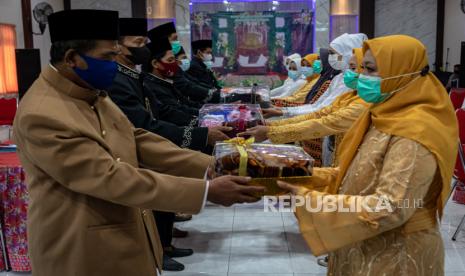 Sejumlah mempelai pria menyerahkan mahar kepada pasangannya saat mengikuti acara nikah massal di aula Kecamatan Genuk, Semarang, Jawa Tengah, Selasa (12/4/2022). Acara nikah massal yang diselenggarakan secara gratis oleh Dinas Permukiman Kota Semarang, Kemenag Kota Semarang, Baznas Kota Semarang, Perkumpulan Keluarga Berencana Indonesia serta sejumlah lembaga swadaya masyarakat itu diikuti tujuh pasangan penghuni Rusun Pondok Boro Trimulyo Semarang, untuk membantu masyarakat kurang mampu mendapatkan legalitas pernikahan sesuai dengan ketentuan yang berlaku. 