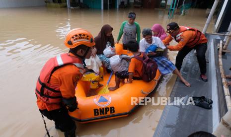 Relawan bersama anggota tim SAR mengevakuasi warga menggunakan perahu karet di lokasi bencana banjir Desa Kebonadem, Brangsong, Kendal, Jawa Tengah, Sabtu (31/12/2022). Hujan lebat sejak Jumat (30/12/2022) sore hingga Sabtu (31/12/2022) menyebabkan bencana banjir di sembilan kecamatan di kabupaten Kendal dengan kedalaman 50 cm hingga 1,5 meter. ANTARA FOTO/Anis Efizudin/aww.