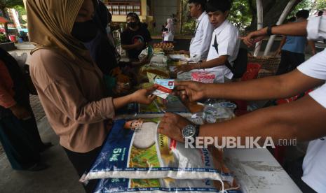 Petugas melayani warga yang datang untuk berbelanja pada gelaran pasar murah di Palu, Sulawesi Tengah, Senin (30/1/2023). Badan Pusat Statistik (BPS) mencatat inflasi pada Januari 2023 sebesar 0,34 persen.