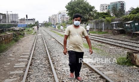 Seorang warga berjalan diatas rel kereta saat hari pertama pemberlakuan lockdown di Dhaka, Bangladesh, Senin (28/6). Pihak berwenang Bangladesh memberlakukan lockdown total secara nasional karena terjadinya peningkatan lonjakan kasus Covid-19. EPA-EFE/MONIRUL ALAMPutra M. Akbar