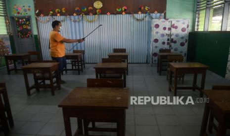 Petugas Sekolah menyemprotkan disinfektan di ruang kelas SDN Petojo Utara 05 Pagi, Jakarta, Sabtu (5/6). Humas Dinas Pendidikan DKI Jakarta Taga Radja Gah mengatakan Uji coba pembelajaran tatap muka tahap II di Provinsi DKI Jakarta kemungkinan mundur dari jadwal semula pada Senin (7/6) menjadi Rabu (9/6).Prayogi/Republika.