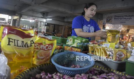 Pedagang menata minyak goreng kemasan rakyat MinyaKita yang dijual di kiosnya di Pasar Kosambi, Bandung, Jawa Barat, Kamis (7/12/2023). Pemerintah berencana melakukan penyesuaian harga eceran tertinggi (HET) untuk minyak goreng kemasan rakyat MinyaKita dari Rp14 ribu menjadi Rp15 ribu per liter. Namun, Menteri Perdagangan Zulkifli Hasan mengatakan, kenaikan HET MinyaKita masih harus dibahas lebih lanjut dengan Menteri Koordinator Bidang Perekonomian Airlangga Hartarto.