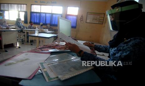 Seorang guru yang mengenakan pelindung wajah dan masker (Ilustrasi). 