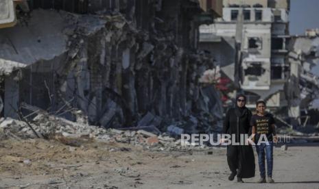 Pengungsi Palestina berjalan di samping bangunan yang hancur di Khan Younis, Jalur Gaza Selatan, Rabu (5/6/2024). Menurut Kementerian Kesehatan Palestina dan Pasukan Pertahanan Israel (IDF), sejak militan Hamas melancarkan serangan terhadap Israel dari Jalur Gaza pada 07 Oktober 2023, dan operasi Israel di Gaza dan Tepi Barat  tercatat Lebih dari 36.000 warga Palestina dan lebih dari 1.400 warga Israel terbunuh. EPA-EFE/MOHAMMED SABER