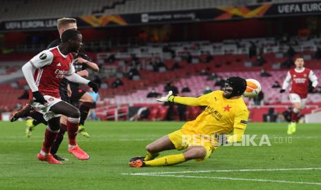 Pemain Arsenal Nicolas Pepe (Kiri) mencetak gol 1-0 melewati penjaga gawang Slavia Praha Ondrej Kolar (kanan) pada perempat final UEFA Europa League, pertandingan leg pertama antara Arsenal dan Slavia Praha di London, Inggris, Jumat (9/4) dini hari WIB