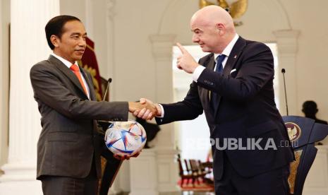 Presiden Indonesia Joko Widodo (kiri) menerima bola dari Presiden Federation Internationale de Football Association (FIFA) Gianni Infantino selama pertemuan di Istana Kepresidenan di Jakarta, Indonesia, 18 Oktober 2022. Infantino mengunjungi Indonesia untuk membahas transformasi sepak bola nasional terutama setelah Tragedi Kanjuruhan pada 1 Oktober 2022 yang menewaskan 132 orang dan ratusan lainnya luka-luka.