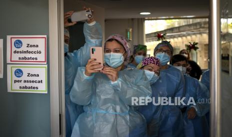  Seorang paramedis mengambil foto dengan ponselnya ke sebuah kotak (tidak terlihat) berisi vaksin Covid-19 setibanya di panti jompo Llarga Laia Gonzalez.