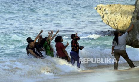 Sejumlah wisatawan berswa foto di obyek wisata Pantai Base G di Jayapura, Papua, Ahad (7/8/2022). Dinas Pariwisata Kota Jayapura, Papua, meminta pemilik tempat wisata khususnya pantai tidak menaikkan harga atau tarif sewa pondok kepada pengunjung selama libur Lebaran 2023.