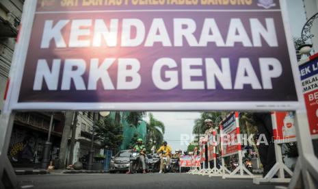 Petugas Kepolisian mengatur lalu lintas saat uji coba pemberlakuan ganjil genap di Jalan Asia-Afrika, Bandung, Jawa Barat, Jumat (13/8/2021). Dinas Perhubungan Kota Bandung bersama Satlantas Polrestabes Bandung melakukan uji coba ganjil genap di sejumlah ruas jalan protokol Kota Bandung guna menekan mobilitas masyarakat pada masa perpanjangan PPKM level 4. 