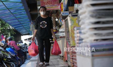 Seorang wanita membawa tas belanja setelah berbelanja makanan di sebuah pasar di Jakarta, Indonesia, Minggu, 14 Agustus 2022. Indonesia dinilai bisa lolos dari jurang resesi meski dunia diramal gelap akibat resesi di 2023 karena ekonomi Tanah Air mulai pulih dan tekanan inflasi mulai melandai. 