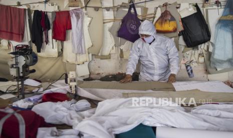 Penjahit memproduksi alat pelindung diri (APD) untuk tenaga medis di Bandung, Jawa Barat, Senin (13/4/2020). Penjahit spesialis seragam dinas dan jaket ini mengalihkan produksinya ke pembuatan APD untuk tenaga medis dalam penanganan pasien COVID-19 di sejumlah rumah sakit umum dan swasta di Jawa Barat dengan jumlah produksi 300 hingga 400 buah per minggu