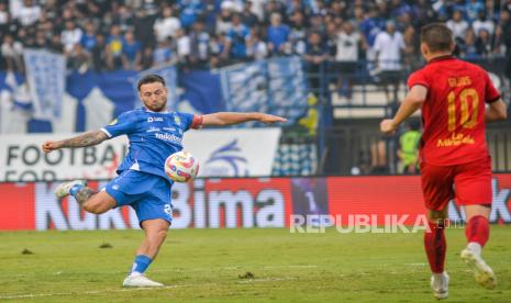 Gelandang Persib Bandung Marc Klok (kiri) menendang bola diadang pemain Persija Jakarta Maciej Gajos pada pertandingan BRI Liga 1 di Stadion Si Jalak Harupat, Kabupaten Bandung. Persib menang 2-0.