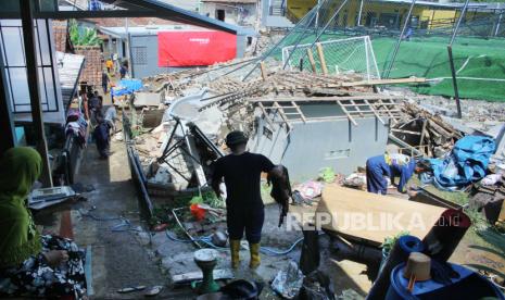 Warga bergotong royong membereskan lokasi yang hancur akibat diterjang banjir bandang di Kampung Balimbing, RT 03 RW 13, Kelurahan Cipageran, Kecamatan Cimahi Utara, Jawa Barat, Selasa (9/1/2024). 