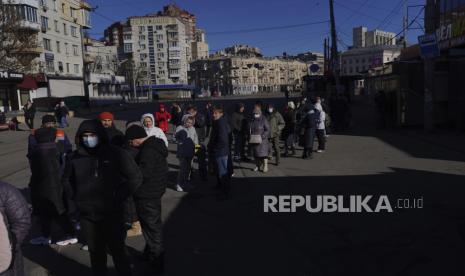  Orang-orang menunggu dalam antrian di luar sebuah supermarket di pusat Kyiv, Ukraina, Senin, 28 Februari 2022. Presiden Vladimir Putin secara dramatis meningkatkan ketegangan Timur-Barat dengan memerintahkan pasukan nuklir Rusia dalam siaga tinggi menyusul sanksi baru yang melumpuhkan dari Barat yang memaksa Bank Sentralnya menaikkan tajam suku bunga utamanya pada hari Senin untuk menyelamatkan rubel dari keruntuhan.