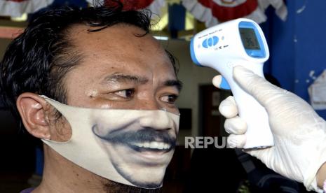 Pengukuran suhu tubuh. Pengidap Covid-19 tidak selalu memiliki gejala demam.