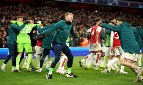 Penjaga gawang Arsenal Aaron Ramsdale (tengah) dan rekan satu timnya merayakan setelah tim memenangkan adu penalti babak 16 besar Liga Champions UEFA, pertandingan leg kedua antara Arsenal dan Porto di London, Inggris, Rabu (13/3/2024) dini hari WIB.