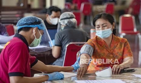  Seorang wanita menjalani pemeriksaan kesehatan sebelum menerima suntikan vaksin COVID-19 saat melakukan vaksinasi di Denpasar, Bali, Indonesia, 09 Maret 2021. Pemerintah Provinsi Bali terus memantapkan kerja sama dengan pelaku pariwisata untuk mempercepat pelaksanaan vaksinasi Covid-19. Ini sejalan dengan upaya mempercepat pemulihan ekonomi Bali.