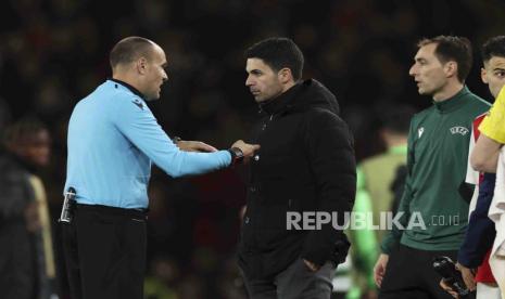 Wasit Antonio Mateu Lahoz berbincang dengan pelatih Arsenal, Mikel Arteta seusai Arsenal kalah di Liga Europa, Jumat (17/3/2023). 