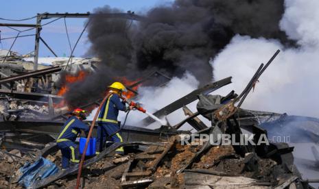 Petugas pemadam kebakaran memadamkan api di gudang yang hancur yang menjadi sasaran serangan udara Israel pada Senin, (19/2/2024).