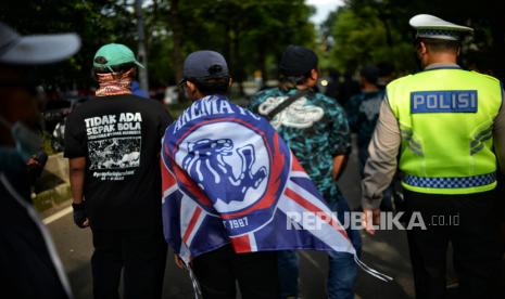 Massa suporter Aremania melakukan aksi saat mengantar keluarga korban menyampaikan laporan terkait Tragedi Kanjuruhan di depan Mabes Polri, Jakarta, Sabtu (19/11/2022). Dalam aksinya, mereka mendesak pihak kepolisian untuk segera menuntaskan kasus dugaan penganiayaan serta meminta kejelasan atas pelaporan yang diajukan keluarga korban dalam Tragedi Kanjuruhan yang menyebabkan sebanyak 135 korban jiwa. Republika/Thoudy Badai