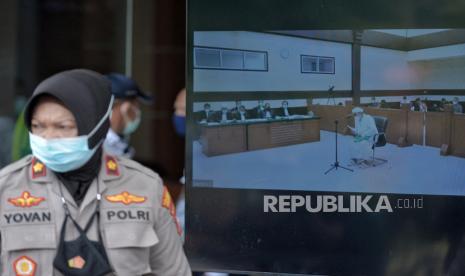 Layar yang menampilkan suasana sidang lanjutan kasus pelanggaran protokol kesehatan dengan terdakwa mantan Pemimpin Front Pembela Islam Rizieq Shihab yang digelar secara virtual di Pengadilan Negeri Jakarta Timur, Jumat (25/3). Hakim mengabulkan permohinan Rizieq shihab untuk hadir langsung dalam sidang yang beragendakan pembacaan eksepsi. Republika/Thoudy Badai