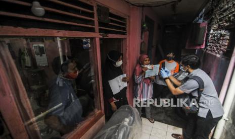 Petugas memotret warga RW 05 Kelurahan Kenari penerima Bantuan Sosial Tunai (BST) sebagai tanda bukti di kawasan Kelurahan Kenari, Senen, Jakarta, Rabu (6/1). Pemerintah menyalurkan Bantuan Sosial Tunai (BST) untuk empat bulan kedepan sebesar Rp 300.000 per Keluarga Penerima Manfaat (KPM) yang diberikan langsung kepada warga melalui petugas PT Pos Indonesia dan bank-bank milik negara.  