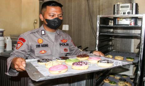 Bripka Dwi Agung, seorang polisi yang bertugas di Bagops Polresta Sidoarjo menunjukkan kue donat di toko miliknya di ruko kawasan Lebo, Suko Salam, Sidoarjo, Jawa Timur, Senin (1/11/2021). Selain bertugas sebagai polisi, Bripka Dwi Agung juga mengembangkan usaha kue donatnya untuk menambah penghasilan. 