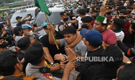 Sejumlah aktivis Himpunan Mahasiswa Islam (HMI) bersitegang dengan polisi saat berunjuk rasa di depan kompleks Parlemen, Senayan, Jakarta, Senin (29/8/2022). Mereka menolak rencana pemerintah menaikkan harga bahan bakar minyak (BBM) subsidi, mencabut kenaikan tarif dasar listrik (TDL), dan mendesak pemerintah untuk memberantas mafia di sektor migas yang merugikan rakyat. 