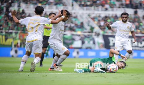 Pesepak bola Persebaya Surabaya Bruno Moreira (kedua kanan) terjatuh usai berebut bola dengan pesepak bola Arema FC Muhammad Rifad Marasabessy (kedua kiri) pada pertandingan BRI Liga 1 di Stadion Gelora Bung Tomo, Surabaya, Jawa Timur, Sabtu (7/12/2024). Persebaya mengalahkan Arema FC dengan skor 3-2. 