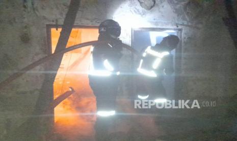 Petugas kebakaran berusaha memadamkan api yang membakar rumah warga di Desa Sayana, Kecamatan Jalaksana, Kabupaten Kuningan, Ahad (30/4/2023) malam. Akibat peristiwa itu, pemilik rumah meninggal dunia. 