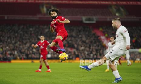 Winger Liverpool Mohamed Salah (tengah) mencoba menghalau tembakan pemain Manchester United Luke Shaw saat pertandingan sepak bola Liga Primer Inggris antara Liverpool dan Manchester United di stadion Anfield di Liverpool, Inggris, Ahad, 17 Desember 2023. 