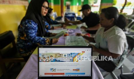 Guru melayani orang tua murid mengajukan pembuatan akun Penerimaan Peserta Didik Baru (PPDB) di SD Grogol Selatan 08, Kebayoran Lama, Jakarta, Senin (20/5/2024). Pemerintah Provinsi DKI Jakarta mulai membuka prapendaftaran PPDB Jakarta 2024 yang harus dilakukan para peserta didik baru sebelum mendaftar PPDB Jakarta 2024 yang rencananya akan dibukan pada Juni 2024.