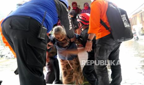 Warga Turgo dibantu petugas turun dari truk angkutan di Barak Pengungsian Purwobinangun, Sleman, Yogyakarta, Rabu (27/1). 