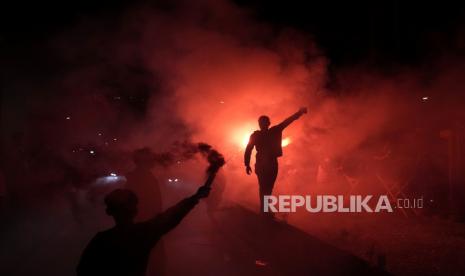 Orang-orang menyalakan suar saat mereka merayakan malam Idul Fitri, hari libur yang menandai berakhirnya bulan suci Ramadhan, di sebuah jalan di Jakarta, Ahad, 1 Mei 2022.