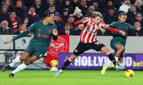  M Mads Roerslev Rasmussen dari Brentford (tengah) beraksi melawan Virgil Van Dijk (kiri) dan Thiago Alcantara dari Liverpool dalam pertandingan sepak bola Liga Primer Inggris antara Brentford FC dan Liverpool FC di Brentford, Inggris, Selasa (3/1/2023) dini hari WIB. Liverpool kalah 1-3.