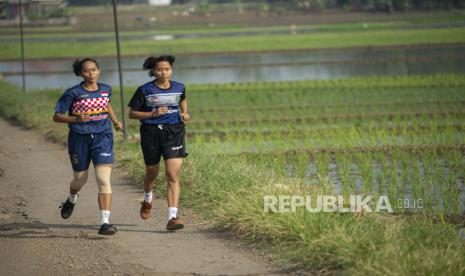 Pesepak takraw Lena (kiri) dan Leni berlatih secara mandiri di kawasan persawahan di Tukdana, Kabupaten Indramayu, Jawa Barat, Senin (15/6/2020). Sejak Maret 2020 kedua atlet yang merupakan saudara kembar peraih medali perunggu Asian Games 2018 dan medali perak Sea Games 2019 Filipina itu berlatih secara mandiri saat masa pandemi COVID-19 untuk menjaga kondisi mereka agar dapat tampil maksimal dalam Pekan Olah Raga Nasional (PON) XX Papua dan meningkatkan prestasi dalam Sea Games 2021 Vietnam