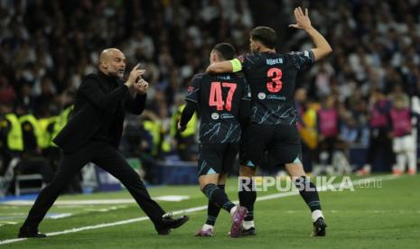 Pelatih kepala Manchester City Pep Guardiola (kiri) merayakan gol 2-2 yang dicetak oleh Phil Foden (tengah) pada pertandingan sepak bola leg pertama perempat final Liga Champions UEFA antara Real Madrid dan Manchester City, di Madrid, Spanyol,  Rabu (10/4/2024). Dini hari WIB.