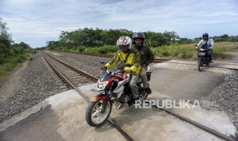 Sejumlah pengendara melintas di perlintasan kereta api sebidang tanpa palang pintu. 