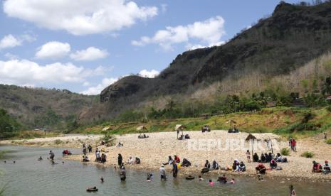 Warga mengisi hari libur di Sungai Opak, kawasan ekowisata Sriharjo, Bantul, Yogyakarta, Ahad (13/9). Kawasan wisata yang dikelola oleh masyarakat ini memanfaatkan potensi alam perdesaan yang masih natural. Sungai Opak yang jernih dan tidak terlalu dalam, serta lansekap pegunungan menjadi daya tarik alternatif wisata yang murah di Yogyakarta.