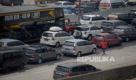 Pemudik keluar dari kendaraannya ketika terjebak kemacetan di Gerbang Tol Cikampek Utama, Purwakarta, Jawa Barat, Sabtu (30/4/2022). 