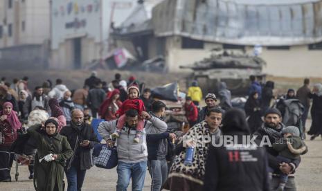  Internally displaced Palestinians move past an Israeli tank after the Israeli army told residents of Khan Yunis camp to leave their homes and head towards Rafah camps near the Egyptian border, southern Gaza Strip, 27 January 2024. Since 07 October 2023, up to 1.9 million people, or more than 85 percent of the population, have been displaced throughout the Gaza Strip, some more than once, according to the United Nations Relief and Works Agency for Palestine Refugees in the Near East (UNRWA), which added that most civilians in Gaza are in 