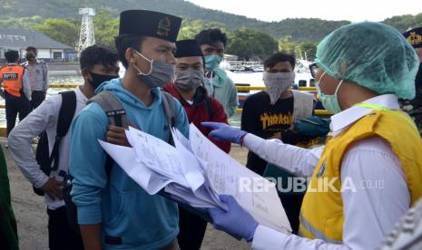 Petugas memeriksa dokumen perjalanan penumpang kapal yang tiba di Pelabuhan Padangbai, Karangasem, Bali, Senin (15/6/2020). Pemeriksaan tersebut dilakukan untuk memastikan seluruh penumpang yang memasuki wilayah Bali melalui pelabuhan tersebut negatif COVID-19 dengan menunjukkan surat keterangan hasil uji rapid test dari daerah keberangkatan sebagai upaya untuk mencegah penyebaran COVID-19