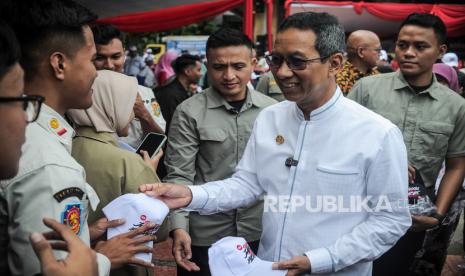 Jakarta Governor Heru Budi Hartono (right) gives a speech to Satpol PP officers at Jakarta City Hall, Friday (8/3/2024). Cheap food activities for ASN and Other Service Providers of Individual Persons (PJLP) in the Jakarta Provincial Government neighborhood provide cheap grocery packages worth IDR 150,000 consisting of premium rice, wheat flour, granulated sugar, cooking oil and beef. The activity is an effort to meet the needs of ASN and PJLP Jakarta amid food commodity prices that have been surging for some time.